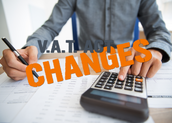 Man in background calculating Taxes, text overlay says VAT Changes